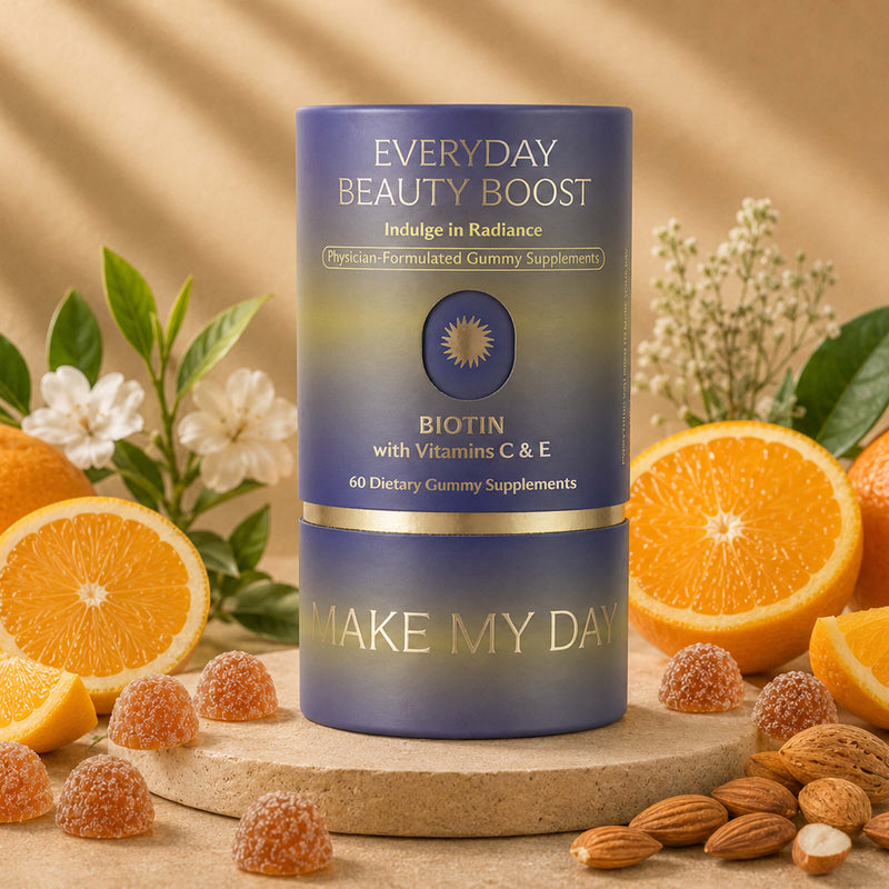 A cylindrical supplement bottle labeled 'EVERYDAY BEAUTY BOOST' and 'BIOTIN with Vitamins C & E' stands on a wooden surface surrounded by orange slices, almonds, and small gummy candies. The bottle has a blue-to-purple gradient label with gold accents and the brand name 'MAKE MY DAY' near the bottom.